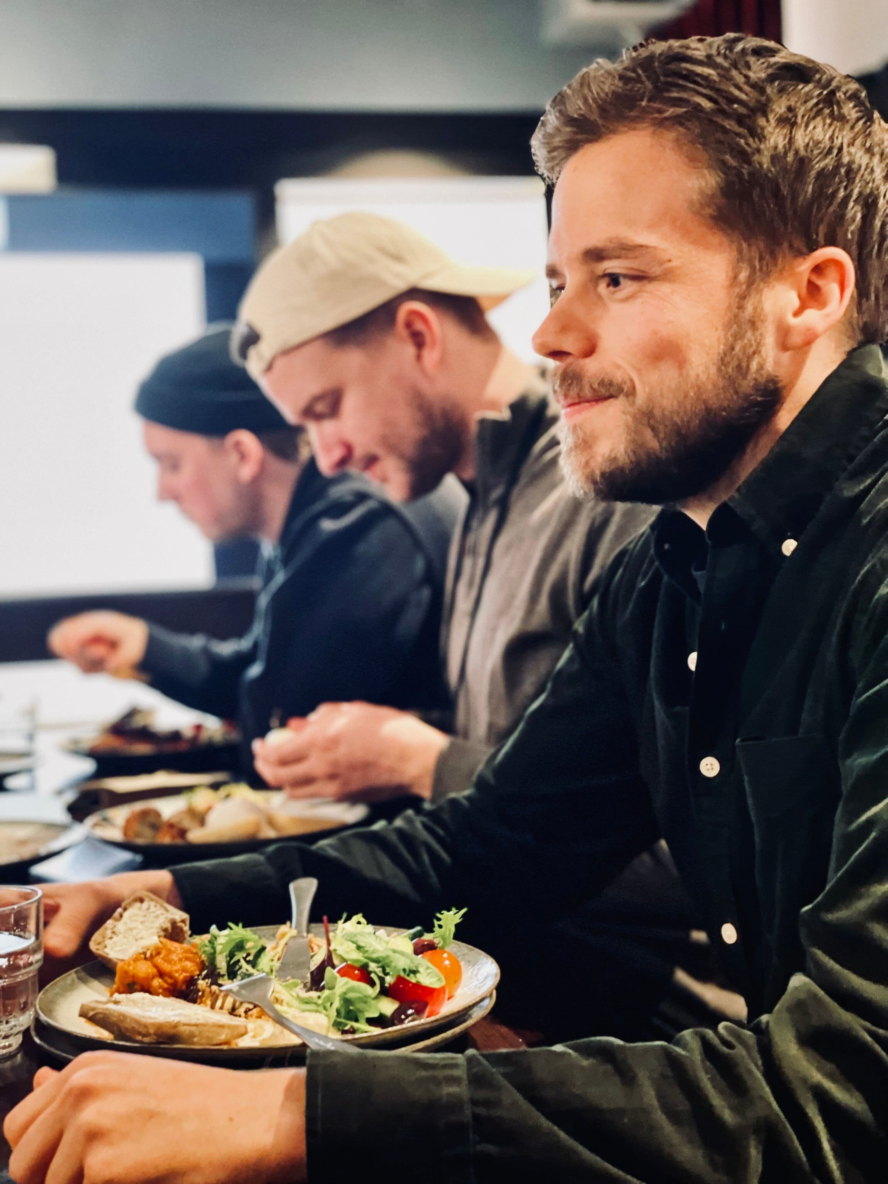 Kollegaer koser seg med lunsj på klubbhuset